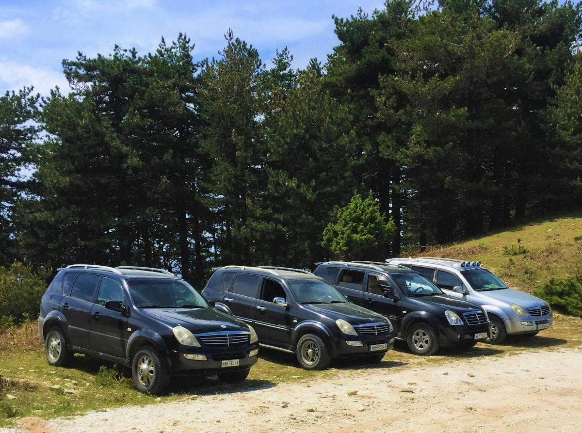 a group of cars parked on a dirt road