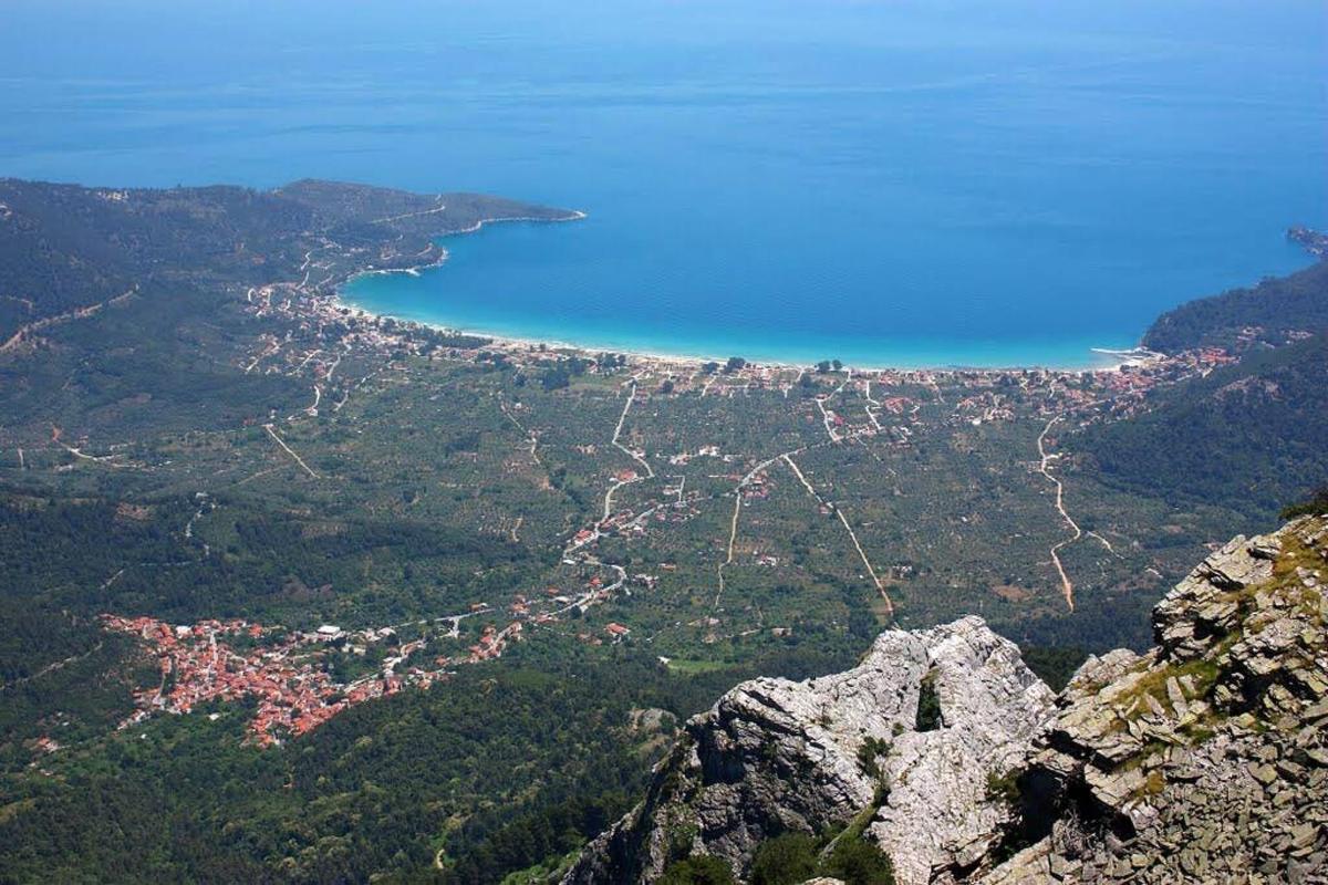 a view of a city and the ocean from a mountain