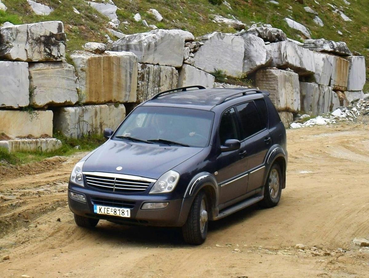 a black suv driving down a dirt road