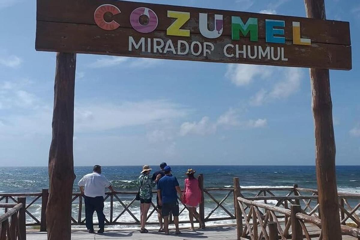 Un grupo de personas de pie en un muelle cerca del océano.