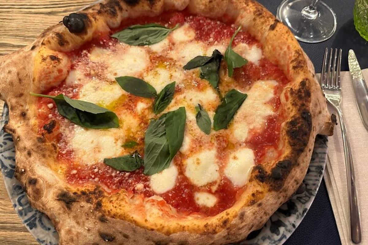 una pizza amb fulles d'alfàbrega en un plat sobre una taula
