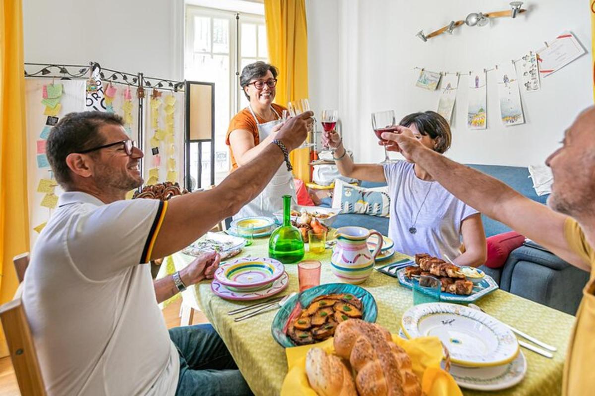 grupė žmonių, sėdinčių prie stalo ir geriančių vyną