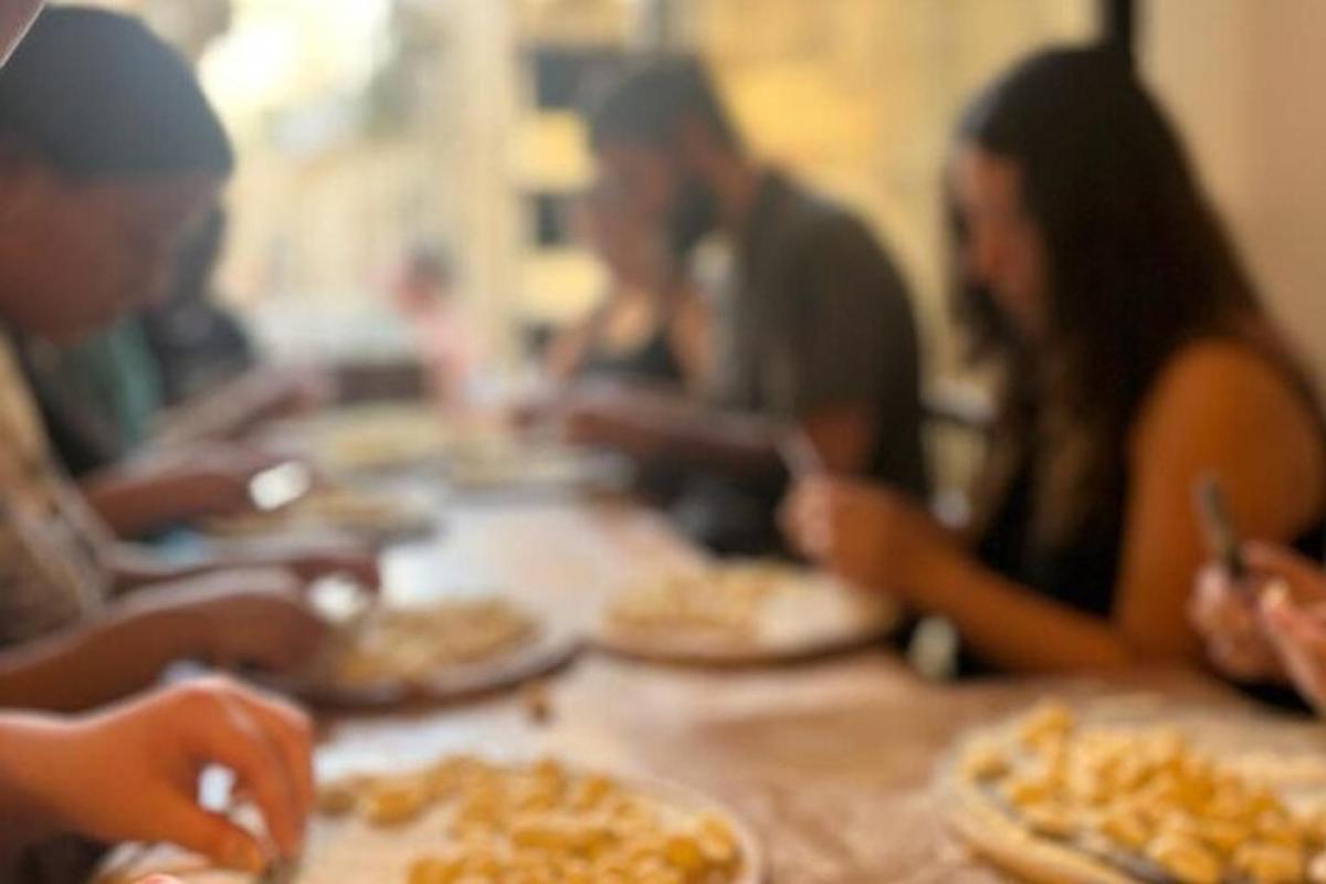 קבוצת אנשים יושבת סביב שולחן ואוכלת פיצה
