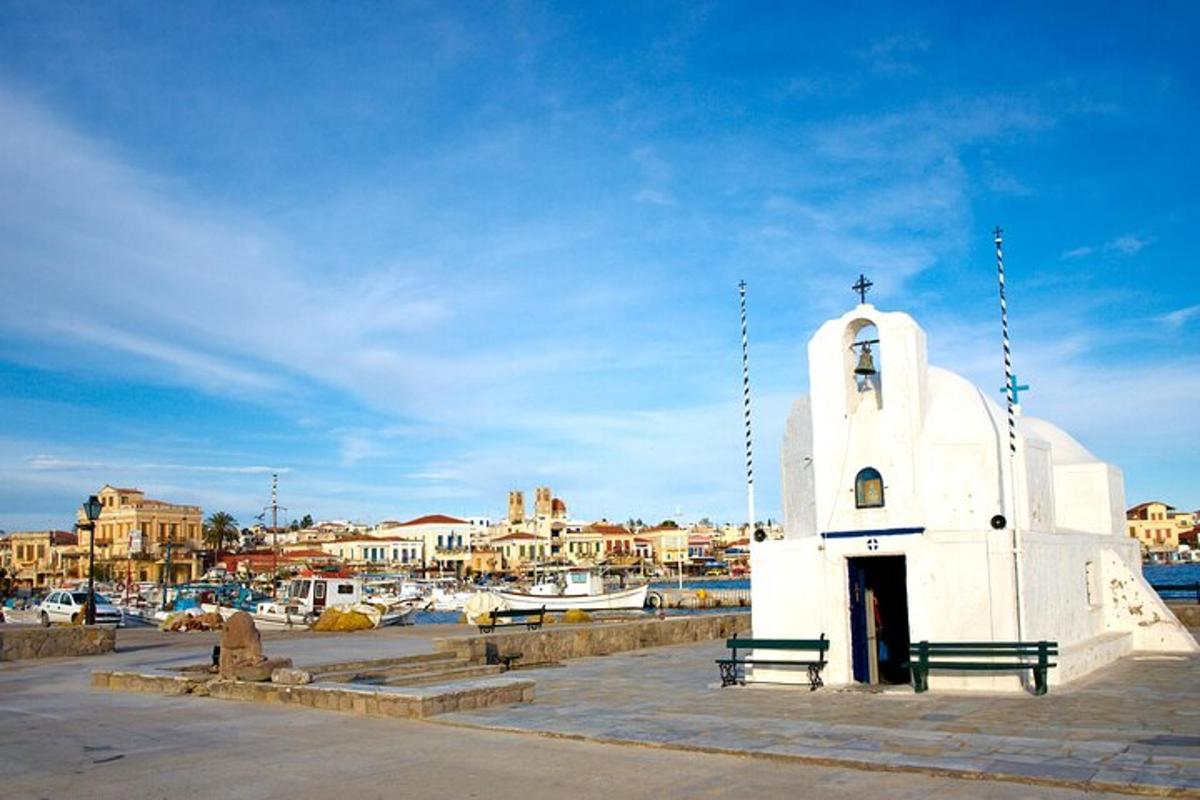 a white building with two benches next to a marina