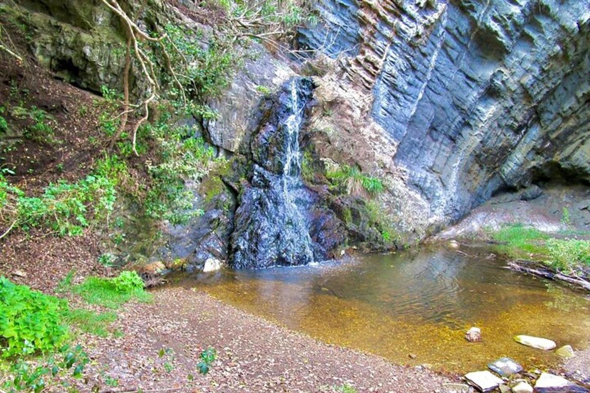 a waterfall on the side of a mountain with water