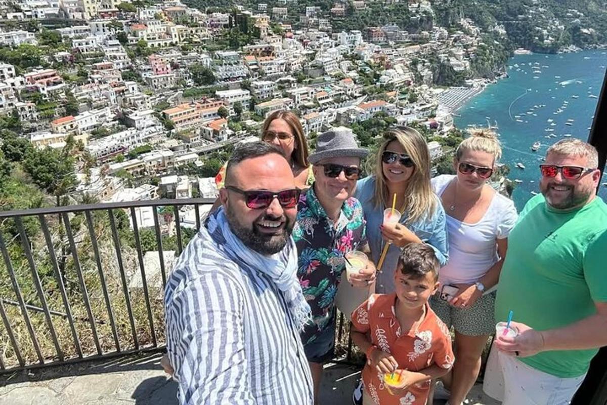 skupina lidí pózujících pro fotografii na balkóně