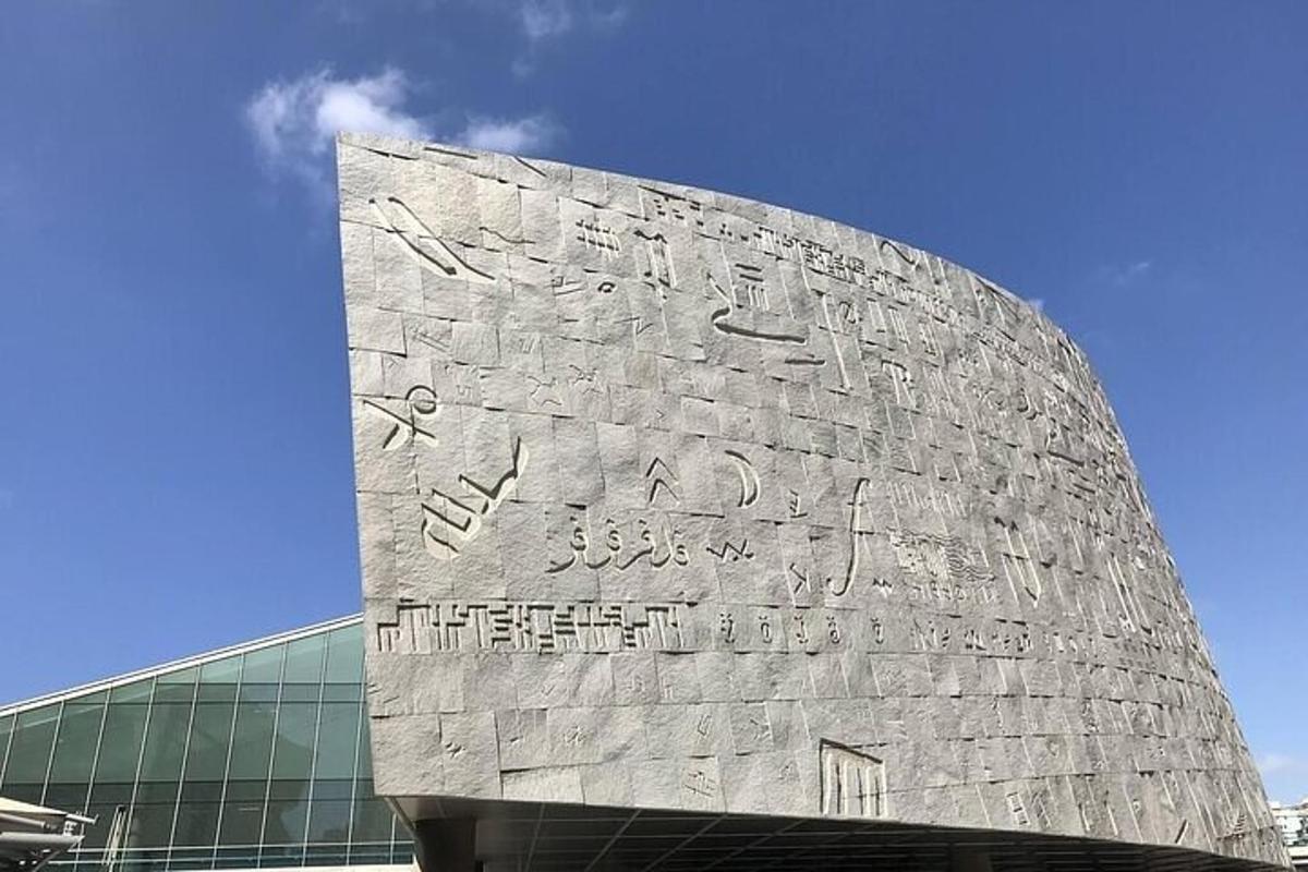 a large stone wall with writing on the side of a building