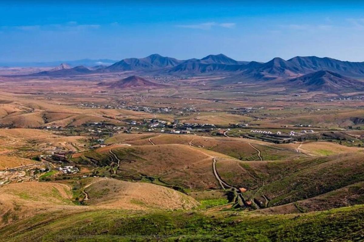 an aerial view of a valley with mountains in the distance