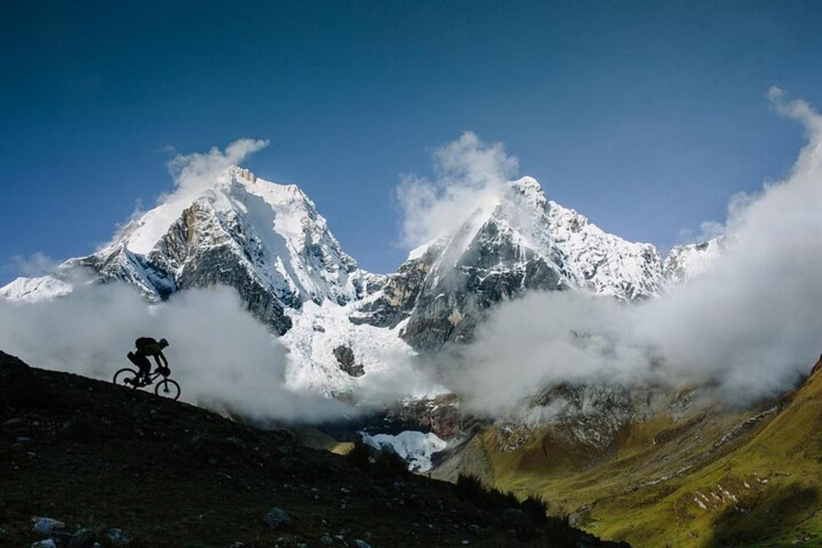 a person riding a bike in front of a snow covered mountain