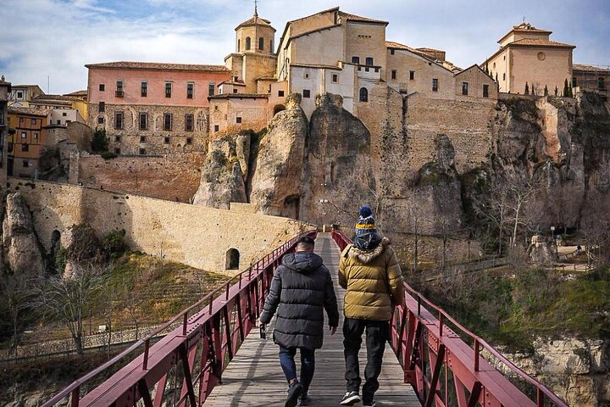 two people walking across a bridge in front of a castle