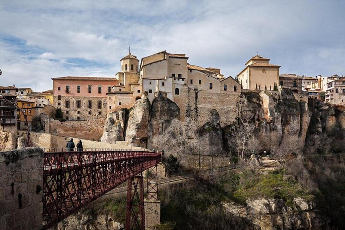 a group of people walking on a bridge over a mountain