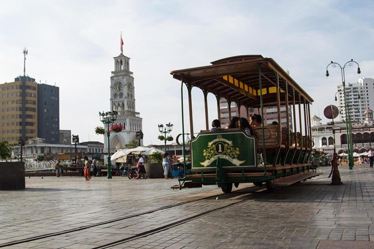 a green trolley car with people riding on it