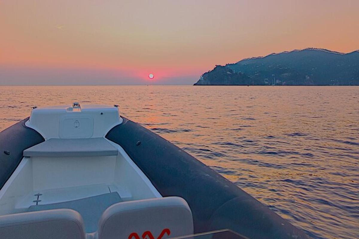 a boat on the water with a sunset in the background