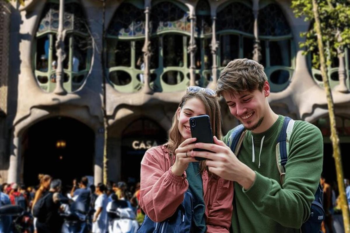 moški in ženska, ki se fotografirata z mobilnim telefonom