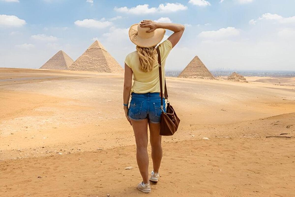 una donna è in piedi davanti alle piramidi