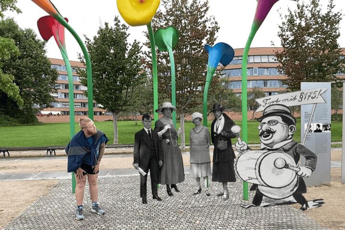 en mann som står ved siden av en statue av en gruppe mennesker