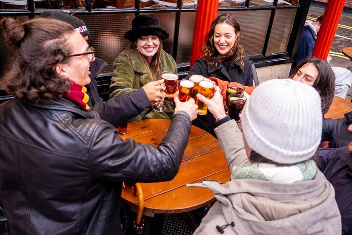 un gruppo di persone sedute attorno a un tavolo a bere birra