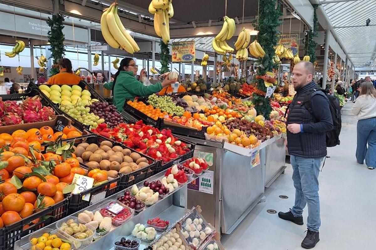 due persone in piedi in un mercato con frutta e verdura