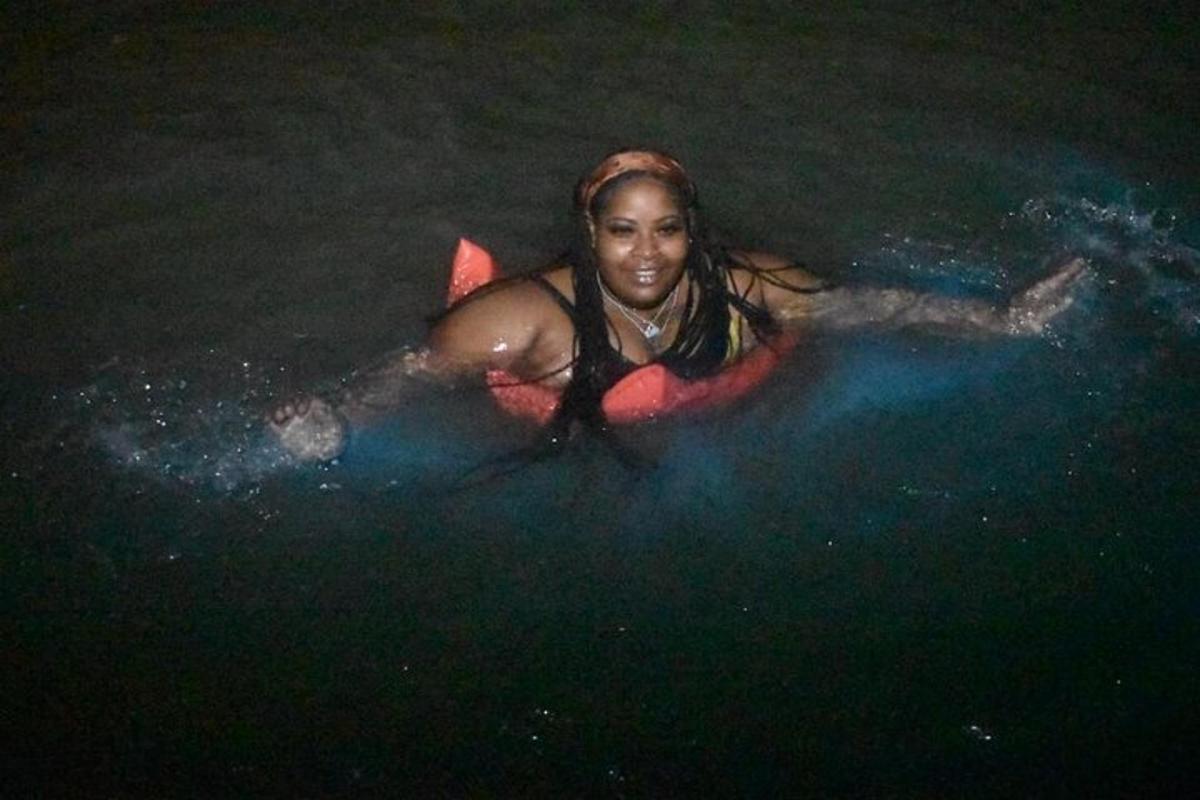 uma mulher deitada em uma prancha de surfe na água