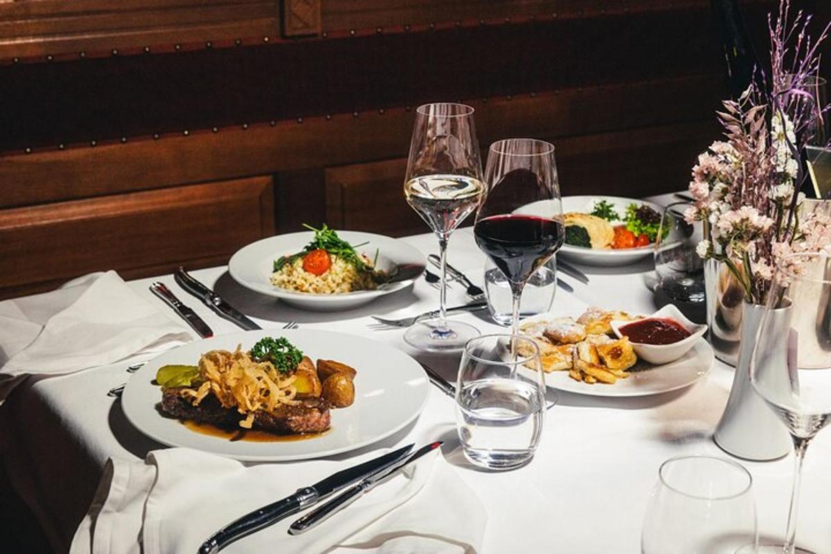uma mesa com pratos de comida e copos de vinho