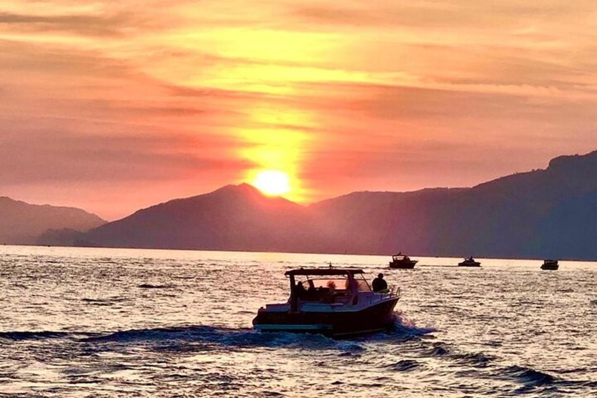 una barca in acqua con il tramonto sullo sfondo
