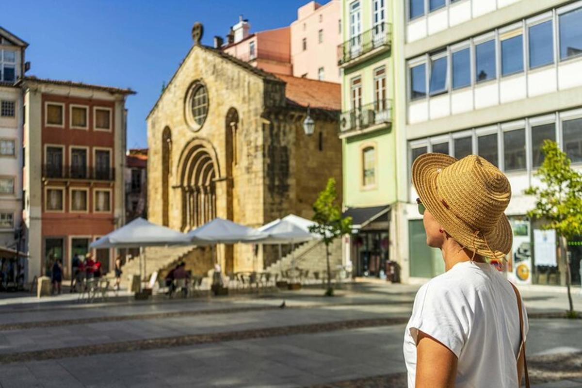 eine Frau mit Strohhut, die ein altes Gebäude betrachtet