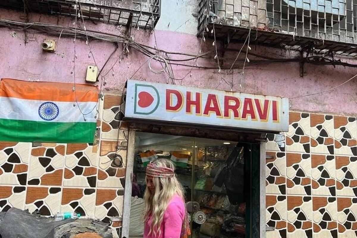 a woman walking in front of a shop with a flag