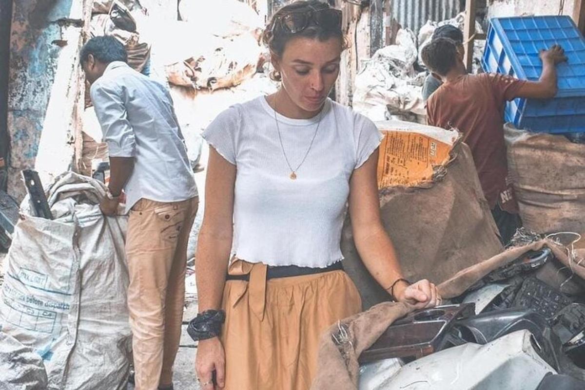 a woman is standing next to a pile of trash