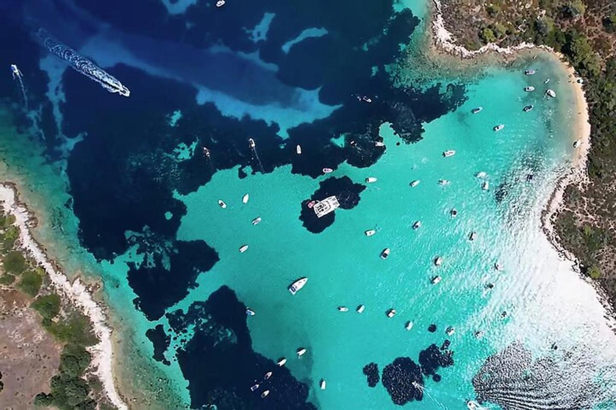 an aerial view of a beach with boats in the water