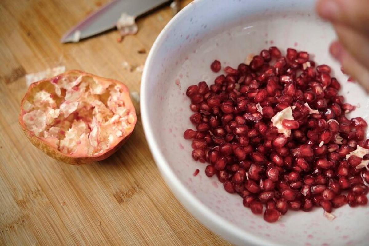 skál af granateplum á borði með skál af sósu