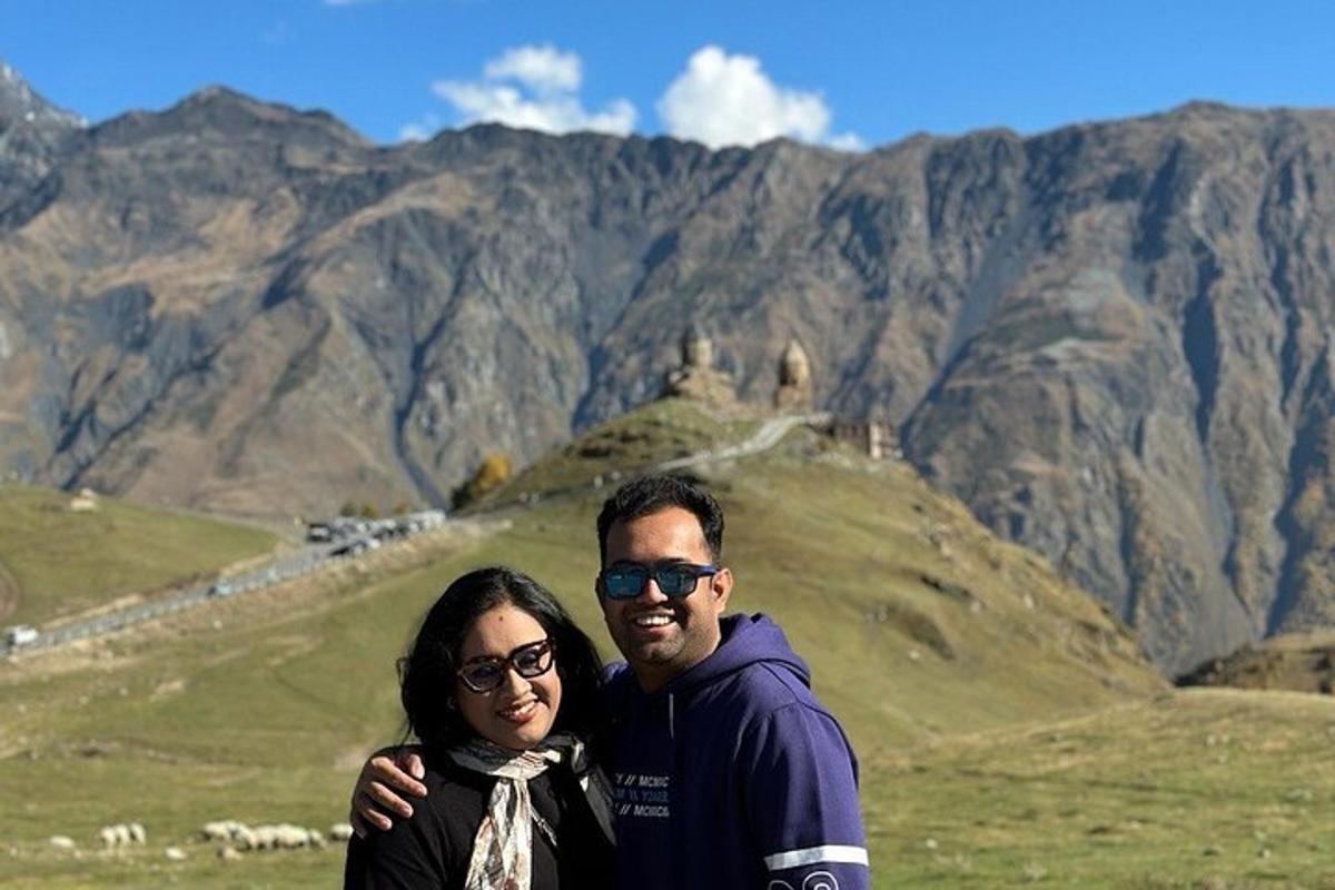 Un hombre y una mujer de pie frente a una montaña
