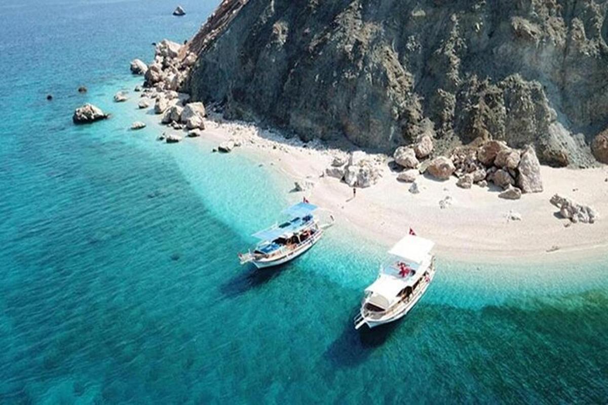 dos barcos en el agua junto a una playa