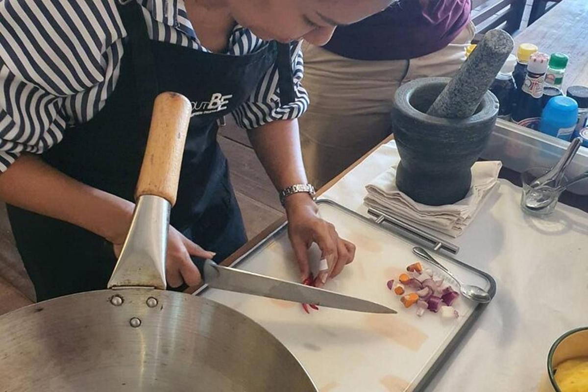uma mulher cortando comida em uma tábua de corte com uma faca