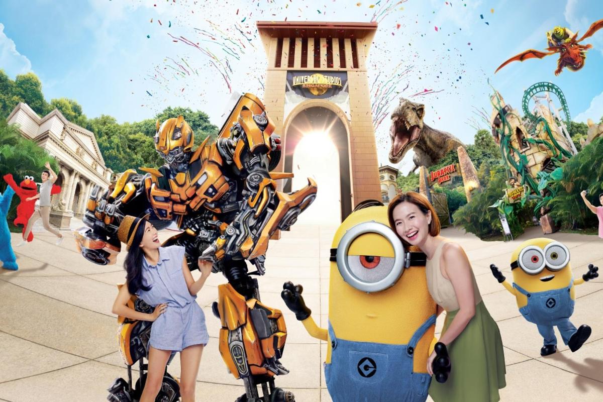 žena a dívka pózující vedle robotů v zábavním parku