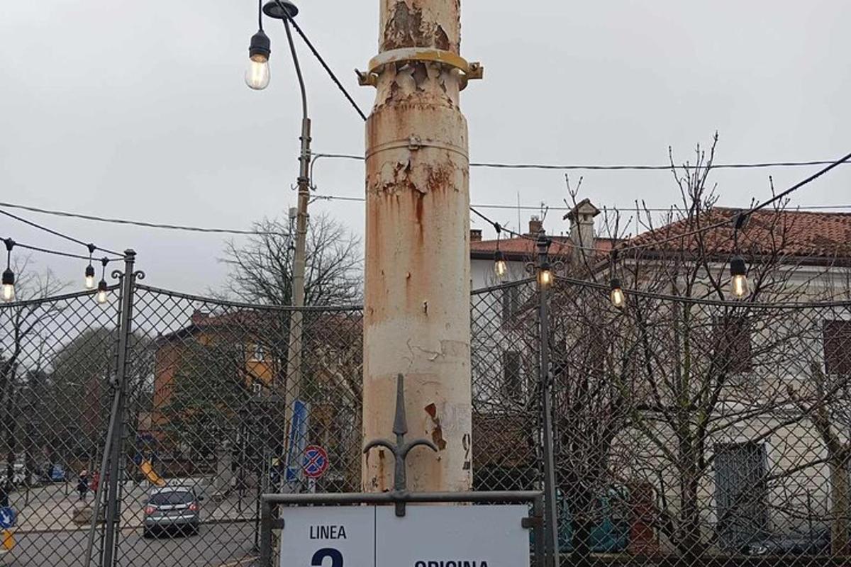 a pole with a sign in front of a fence