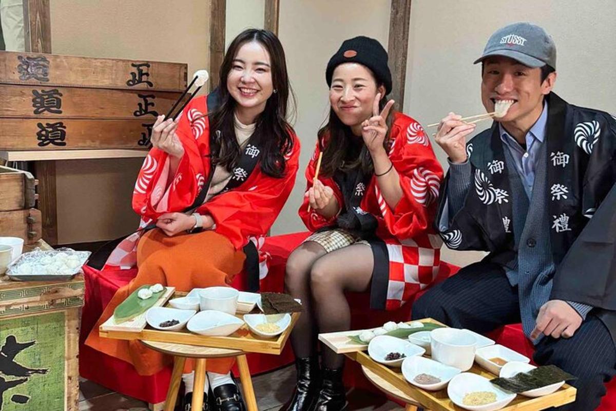 a group of three people eating food with chopsticks