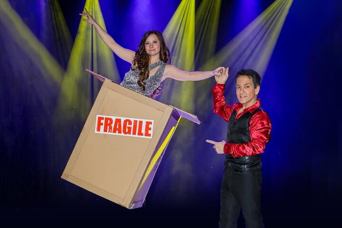 a man and woman standing next to a box with a fragile sign
