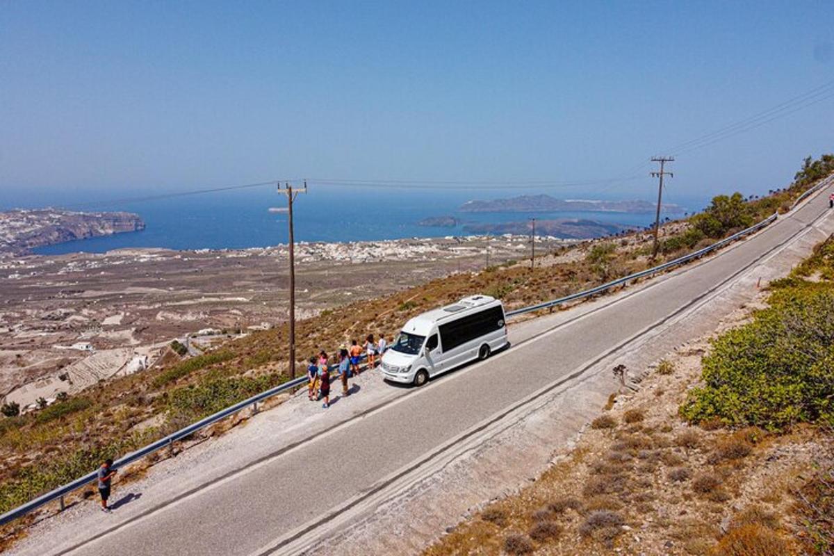 Μια ομάδα ανθρώπων που στέκονται δίπλα σε ένα άσπρο βαν σε έναν δρόμο