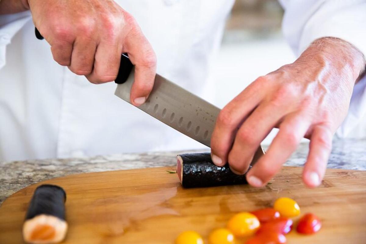 una persona che taglia i pomodori su un tagliere con un coltello