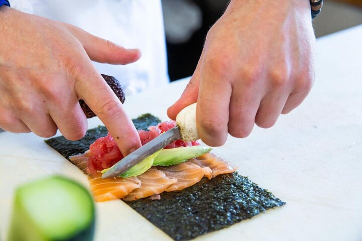 una persona che taglia un pezzo di sushi con un coltello