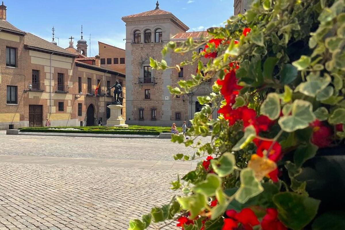 a building with a bunch of red flowers in the foreground