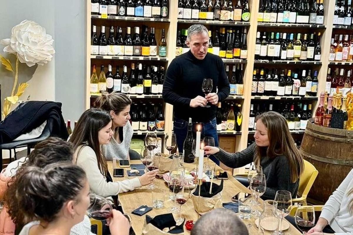 grupp inimesi istub laua ümber veiniklaasidega