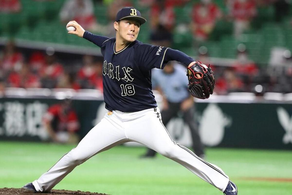 egy baseballjátékos labdát dob a pályán