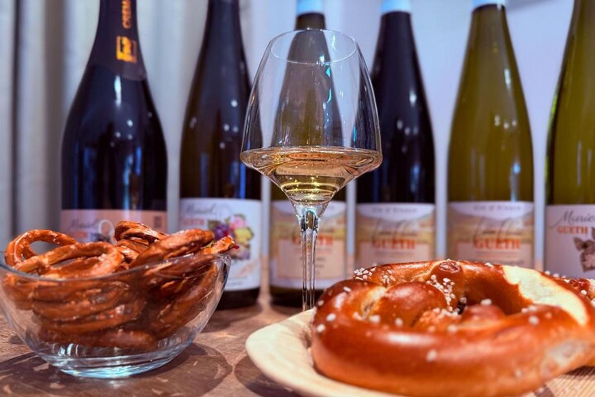 a glass of wine next to a plate of donuts and wine bottles