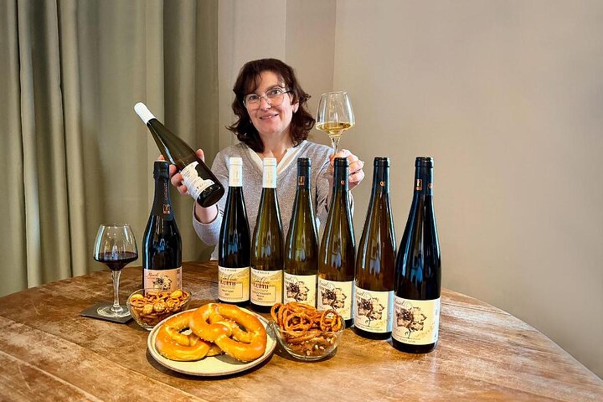 a woman holding a bottle of wine and a bunch of wine glasses