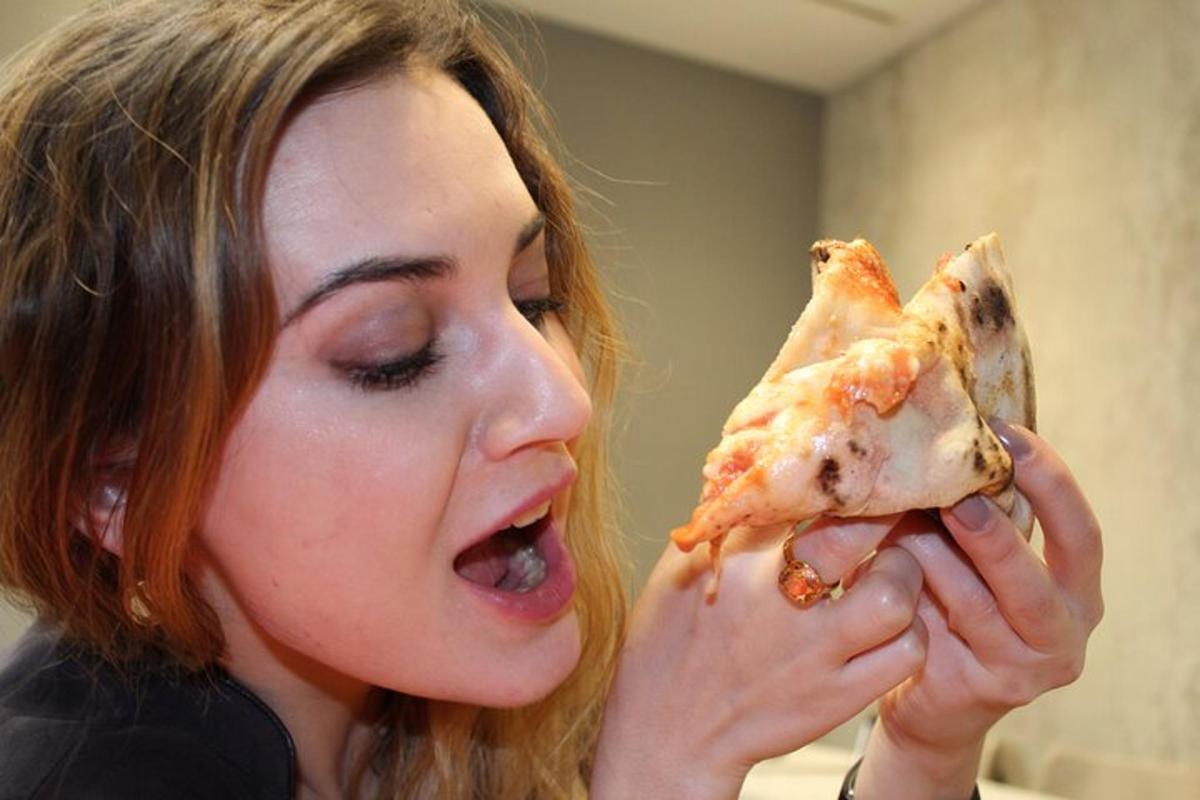 kobieta je kawałek pizzy