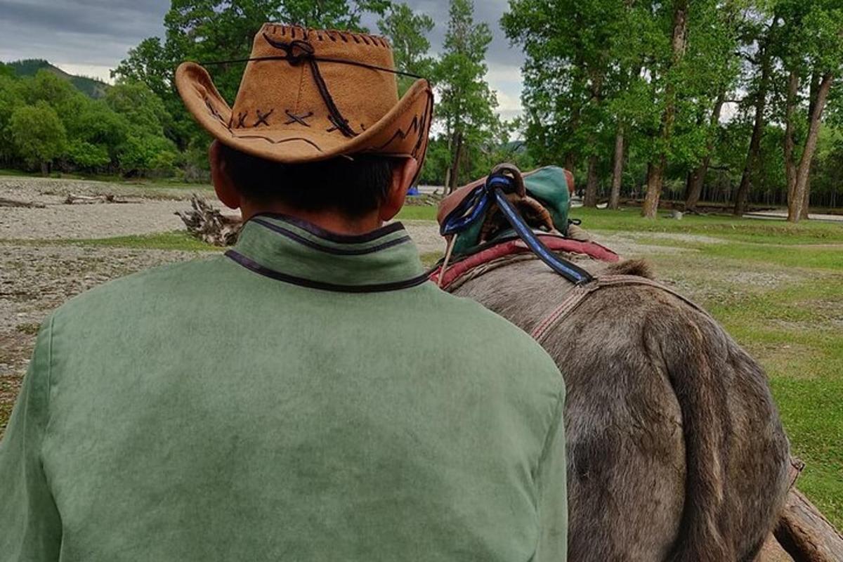 a man wearing a cowboy hat riding a horse