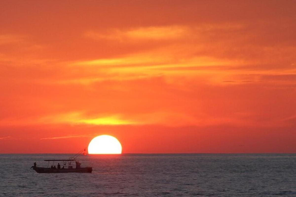 loď v oceánu se západem slunce