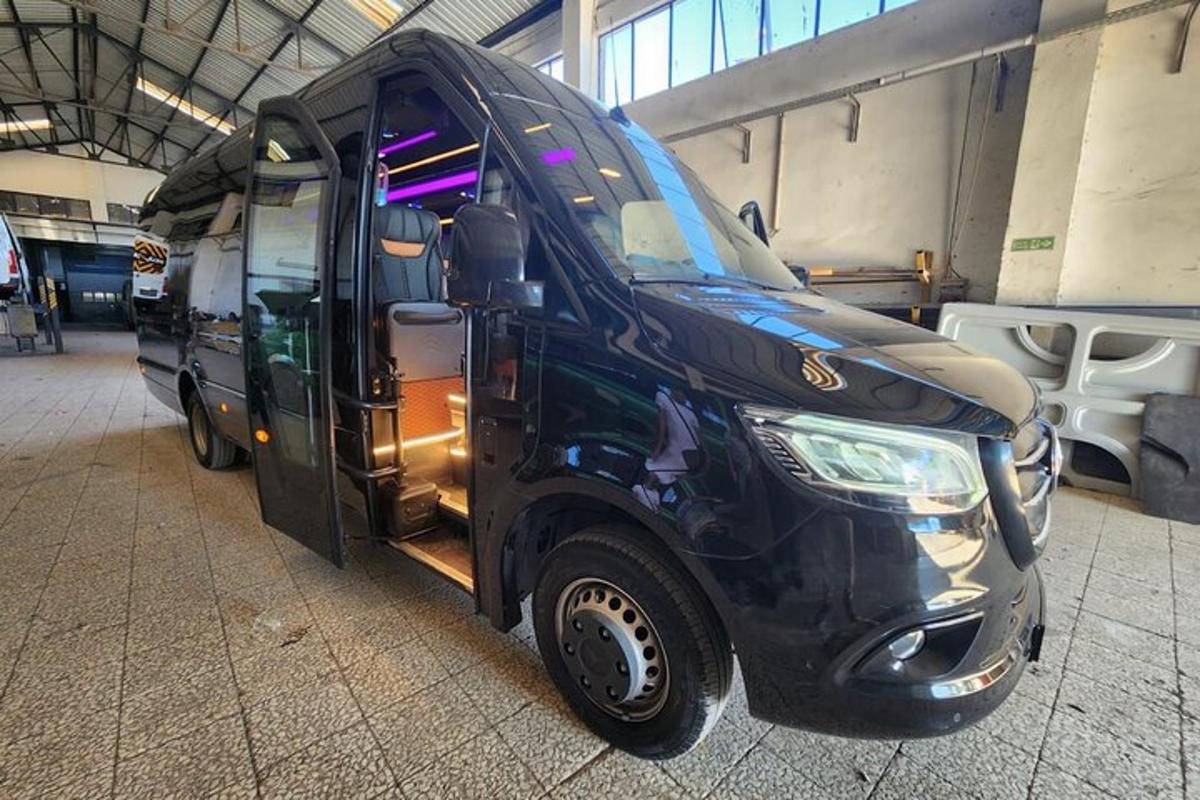črn kombi parkiran v stavbi z odprtimi vrati