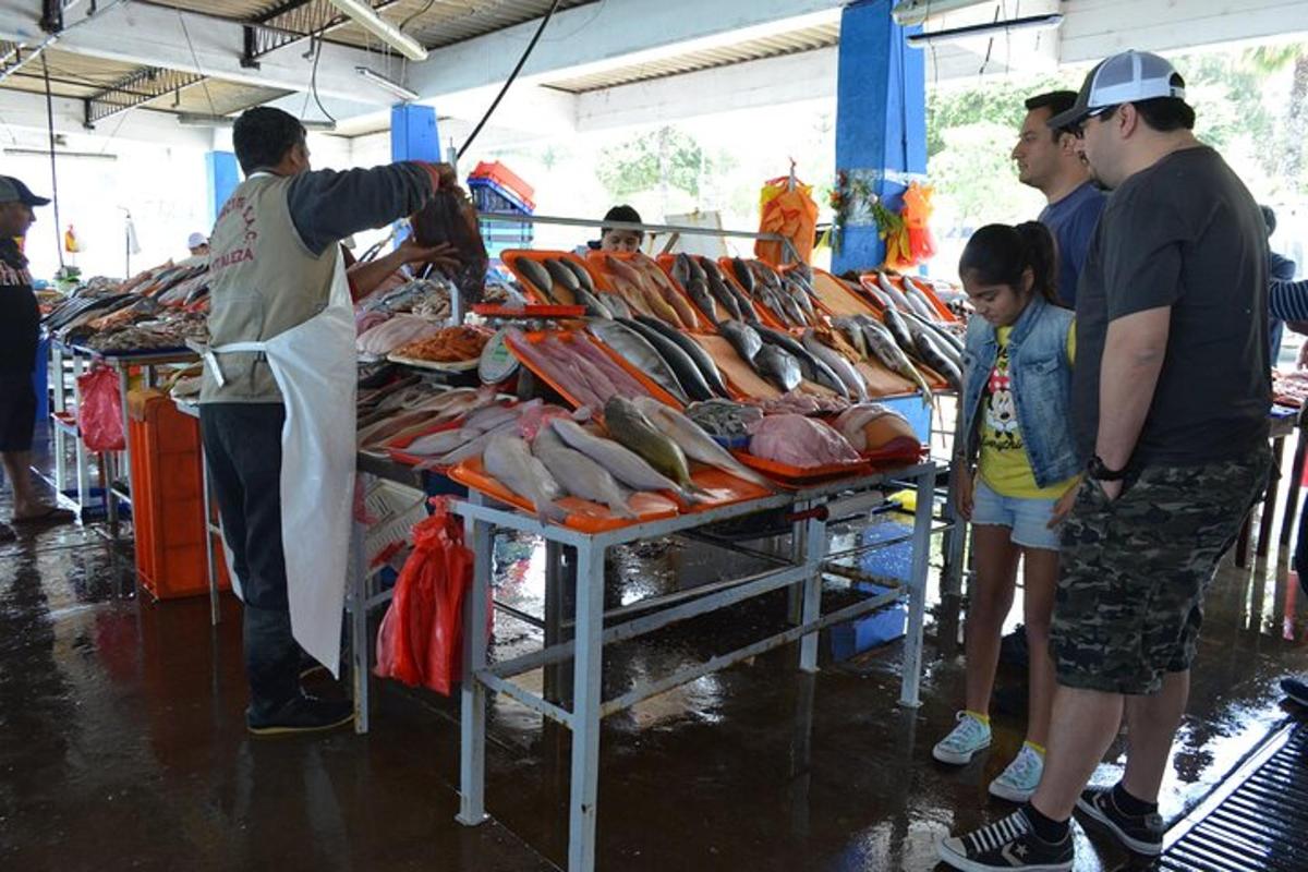 un gruppo di persone che guardano un tavolo di pesce